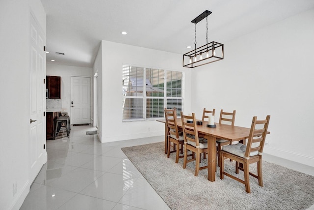 dining area with light tile patterned floors and an inviting chandelier