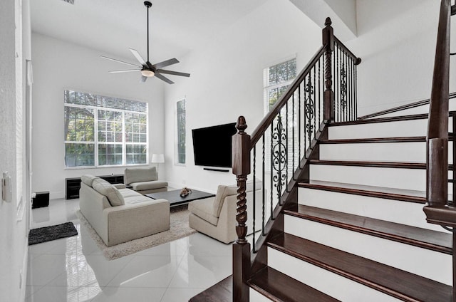 tiled living room with a wealth of natural light and ceiling fan