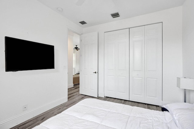 bedroom with hardwood / wood-style flooring, a closet, and ceiling fan