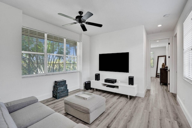 living room with light hardwood / wood-style floors, a wealth of natural light, and ceiling fan