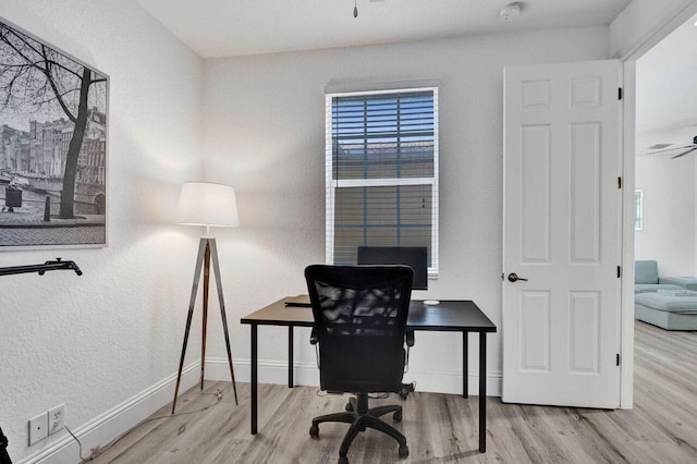 office area with light wood-type flooring and ceiling fan