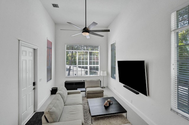 living room with carpet flooring, a towering ceiling, and ceiling fan