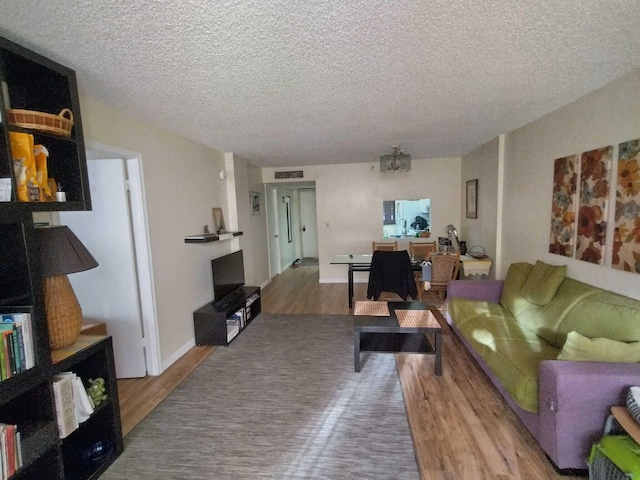 living room with a textured ceiling and hardwood / wood-style flooring