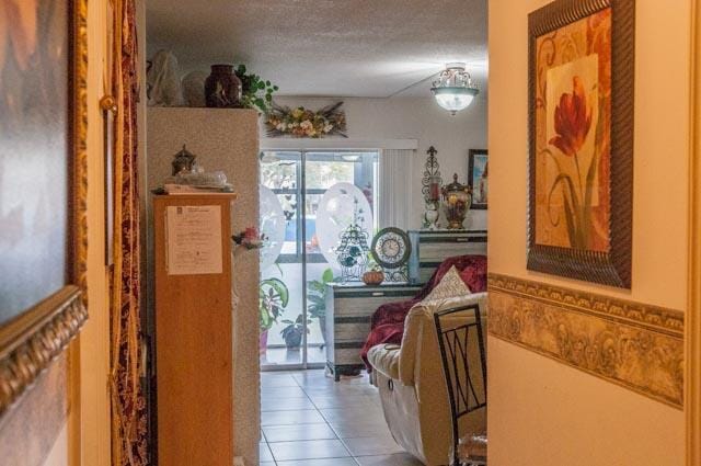 hallway with tile patterned flooring and a textured ceiling