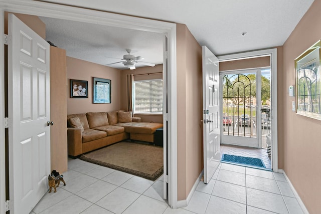 tiled foyer featuring ceiling fan and a textured ceiling