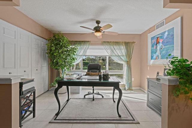 tiled office featuring a textured ceiling and ceiling fan