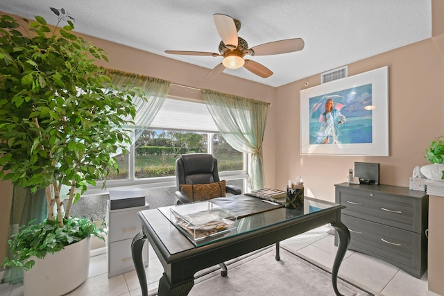 office with a textured ceiling, ceiling fan, and light tile patterned flooring