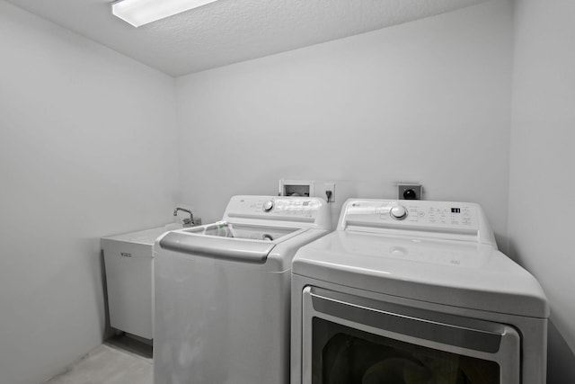 laundry room featuring a textured ceiling and washer and clothes dryer