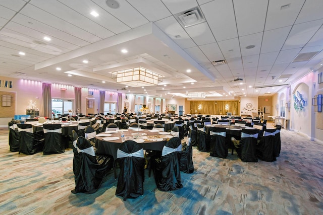 carpeted dining room with a tray ceiling