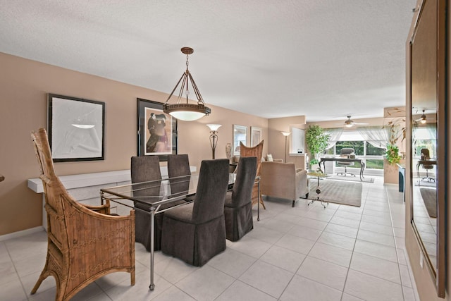 dining space featuring ceiling fan, light tile patterned floors, and a textured ceiling