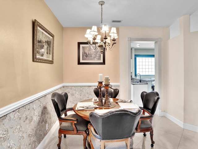 tiled dining space featuring an inviting chandelier and sink