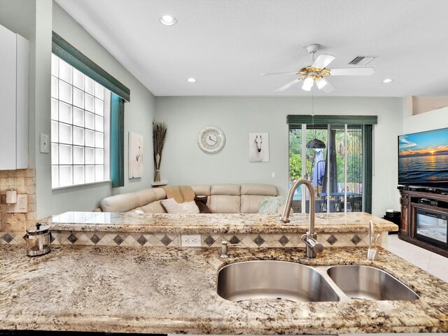 kitchen with decorative backsplash, sink, and ceiling fan