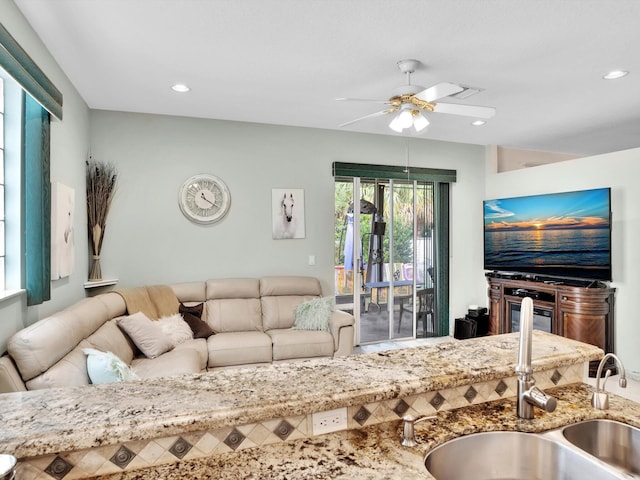 living room featuring ceiling fan and sink