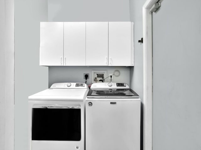 washroom with washing machine and dryer and cabinets