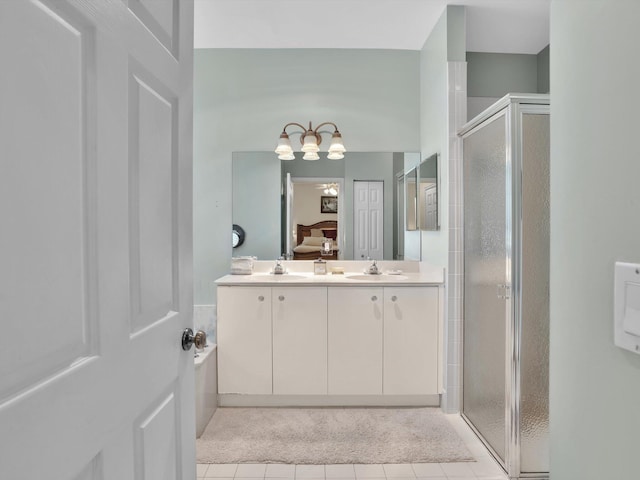 bathroom with tile patterned flooring, vanity, and walk in shower