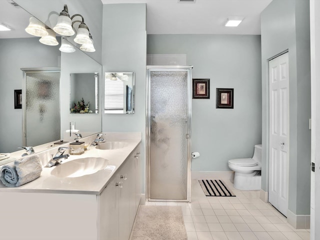 bathroom featuring tile patterned flooring, vanity, an enclosed shower, and toilet