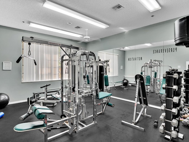 gym featuring ceiling fan and a textured ceiling