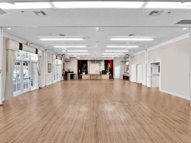 interior space featuring crown molding, light hardwood / wood-style flooring, ceiling fan, and french doors