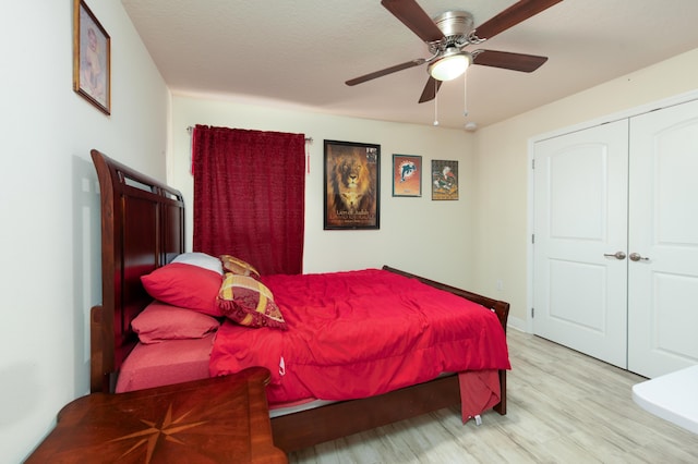 bedroom with a textured ceiling, light wood-type flooring, a closet, and ceiling fan