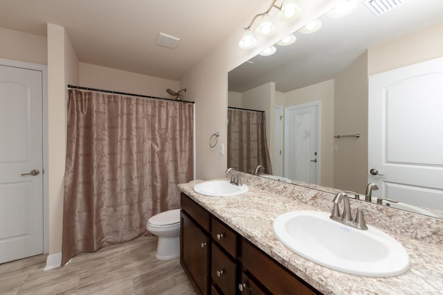 bathroom featuring wood-type flooring, vanity, and toilet