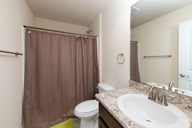 bathroom featuring curtained shower, vanity, a textured ceiling, and toilet