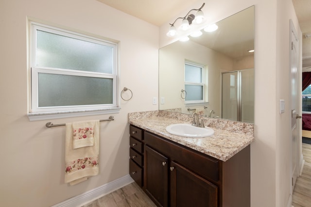 bathroom featuring wood-type flooring, vanity, and a shower with shower door