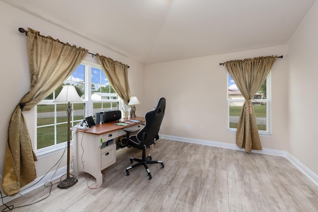 office space with vaulted ceiling and light wood-type flooring