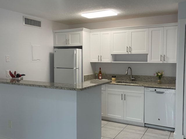 kitchen featuring white cabinetry, sink, stone countertops, and white appliances