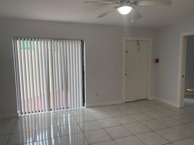 tiled spare room with ceiling fan