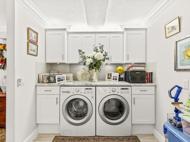 washroom with cabinets, crown molding, light hardwood / wood-style flooring, independent washer and dryer, and a textured ceiling