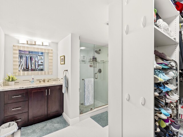 bathroom with tile patterned floors, vanity, and a shower with shower door