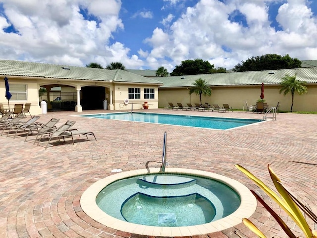 view of pool featuring a patio and a hot tub