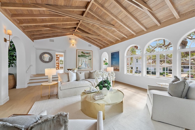 living room featuring beam ceiling, light wood-type flooring, and a wealth of natural light