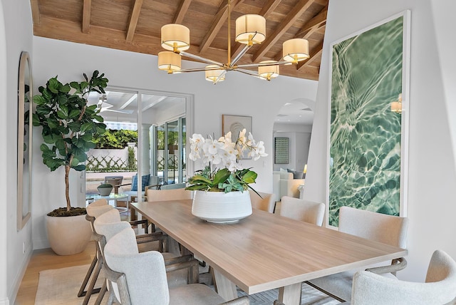 dining room with vaulted ceiling with beams, wooden ceiling, and light hardwood / wood-style floors