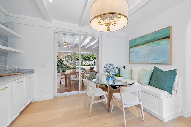 dining room featuring beamed ceiling, light wood-type flooring, and ceiling fan with notable chandelier