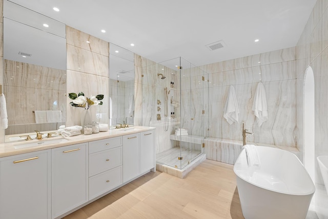 bathroom featuring vanity, shower with separate bathtub, and tile walls