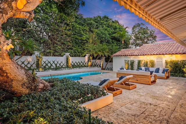 pool at dusk with outdoor lounge area and a patio area