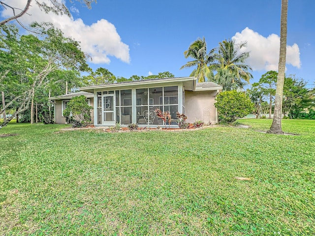 back of property featuring a sunroom and a yard