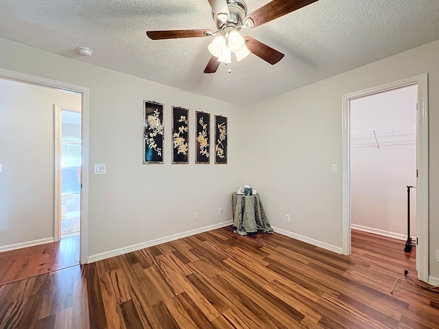 unfurnished room with wood-type flooring, a textured ceiling, and ceiling fan