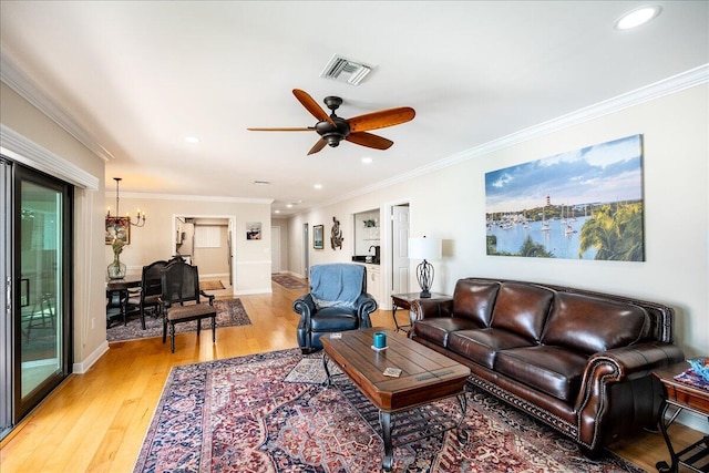 living room with ceiling fan with notable chandelier, wood-type flooring, and crown molding