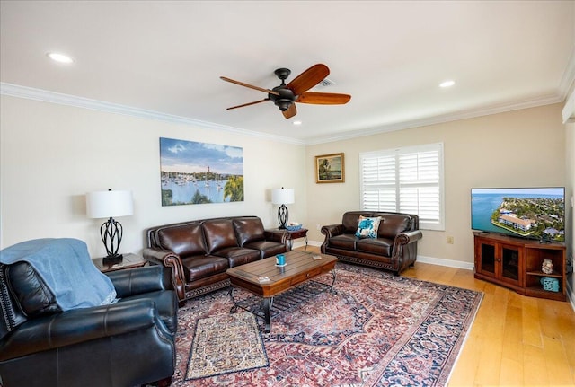 living room featuring ceiling fan, crown molding, and light hardwood / wood-style flooring