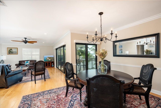 dining space featuring ceiling fan with notable chandelier, hardwood / wood-style flooring, and crown molding