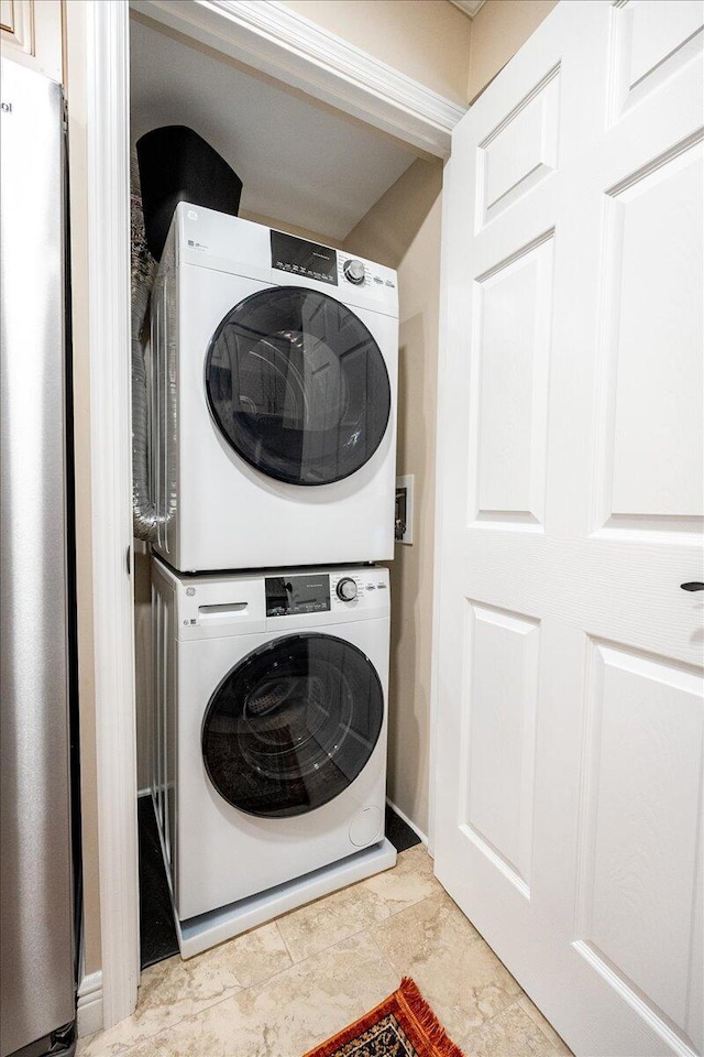 clothes washing area featuring stacked washer and dryer