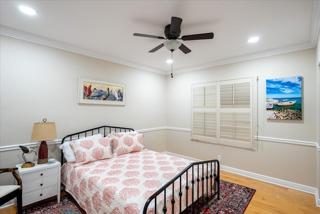 bedroom with hardwood / wood-style floors, ceiling fan, and crown molding