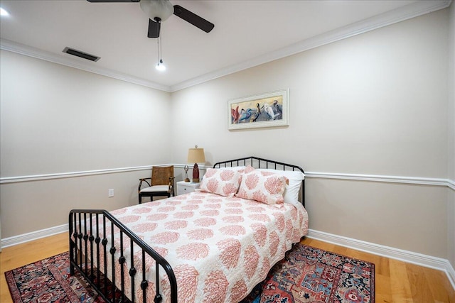 bedroom with hardwood / wood-style floors, ceiling fan, and ornamental molding