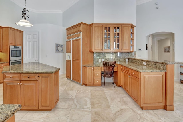 kitchen featuring kitchen peninsula, stainless steel double oven, hanging light fixtures, and a towering ceiling