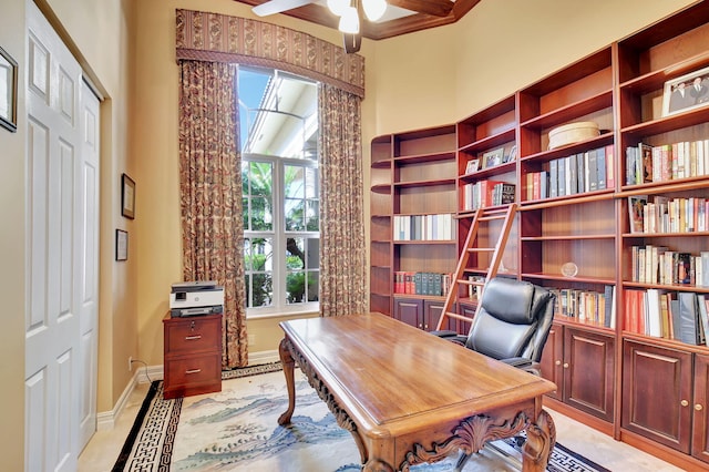 office featuring beamed ceiling, ceiling fan, and a healthy amount of sunlight