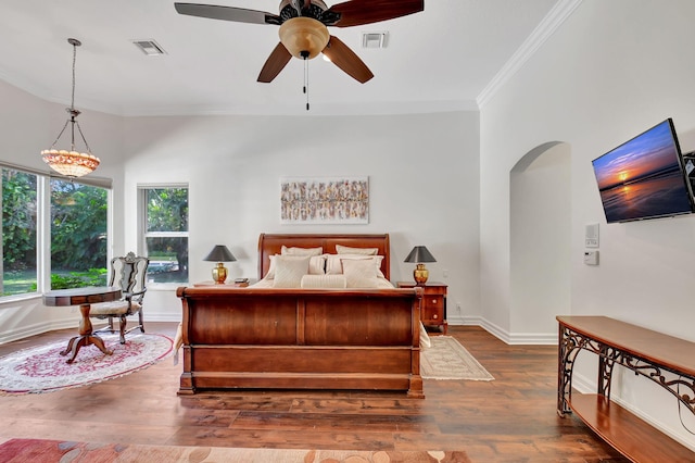 bedroom featuring ceiling fan with notable chandelier, dark hardwood / wood-style floors, and ornamental molding