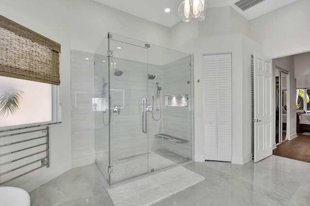 bathroom with radiator, an enclosed shower, and an inviting chandelier