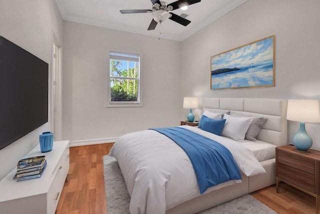 bedroom featuring light hardwood / wood-style floors, ceiling fan, and crown molding